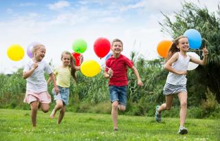 Kinder fröhlich im Park mit Luftballons