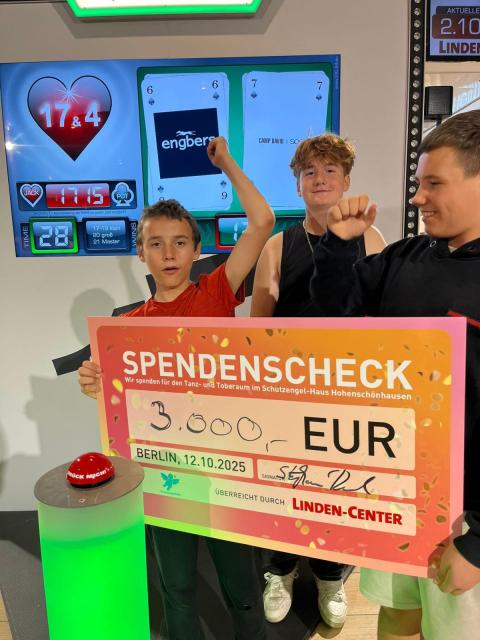 drei Kinder halten einen Spendenscheck
