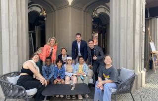 Eine Gruppe von Kindern und Angestellten sitzen vor dem Hotel Luc Berlin